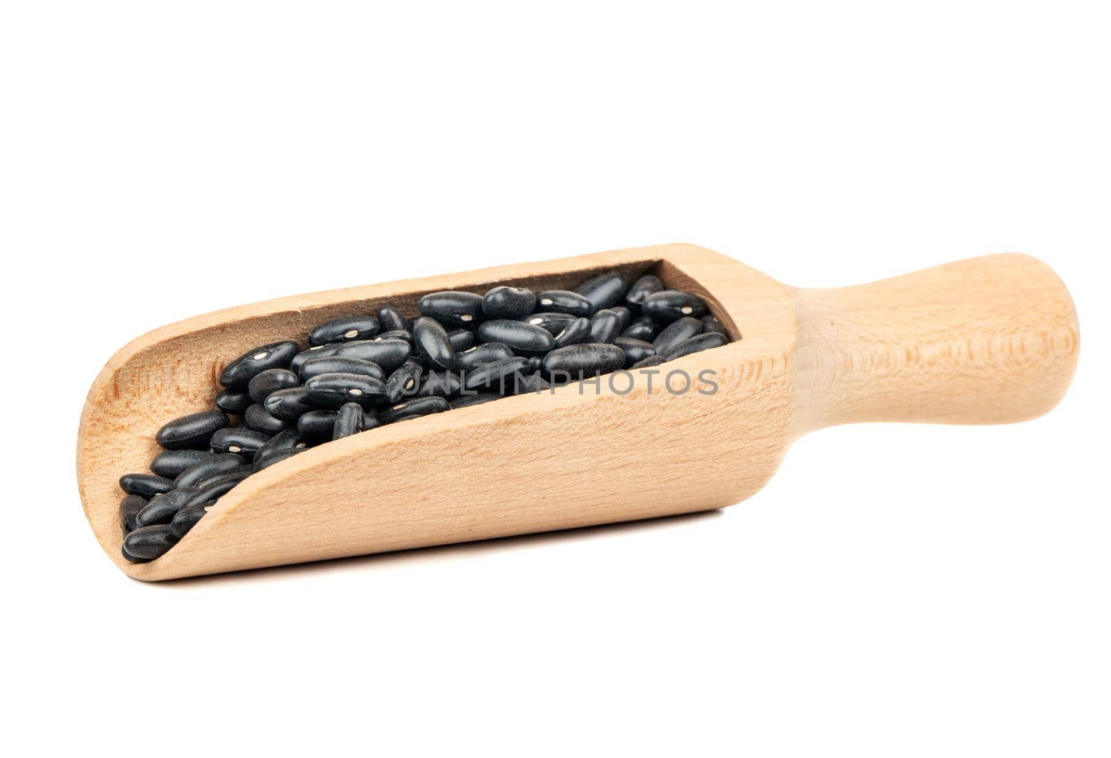 Wooden scoop with black beans isolated on white background