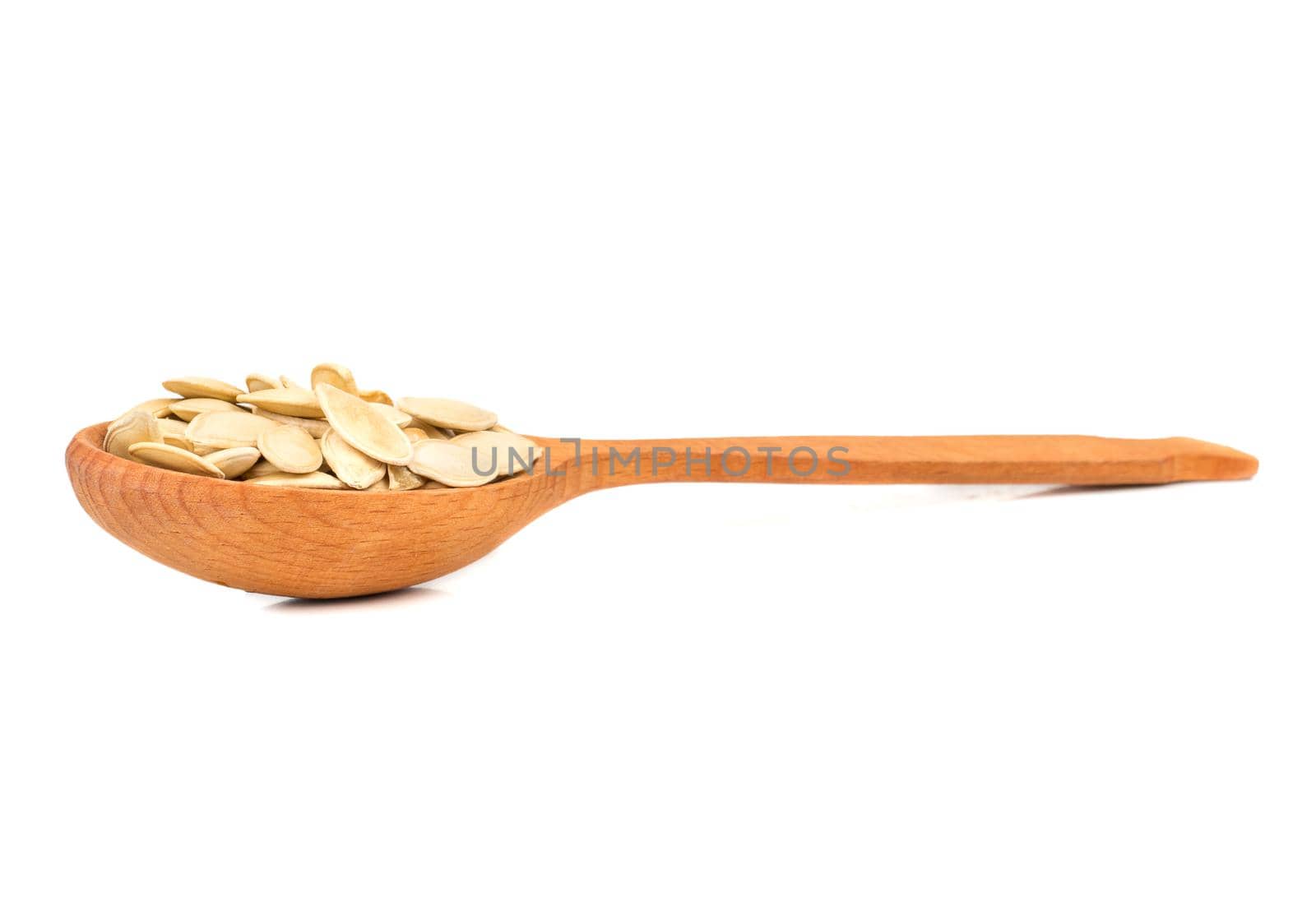 Roasted pumpkin seeds in wooden spoon on white background