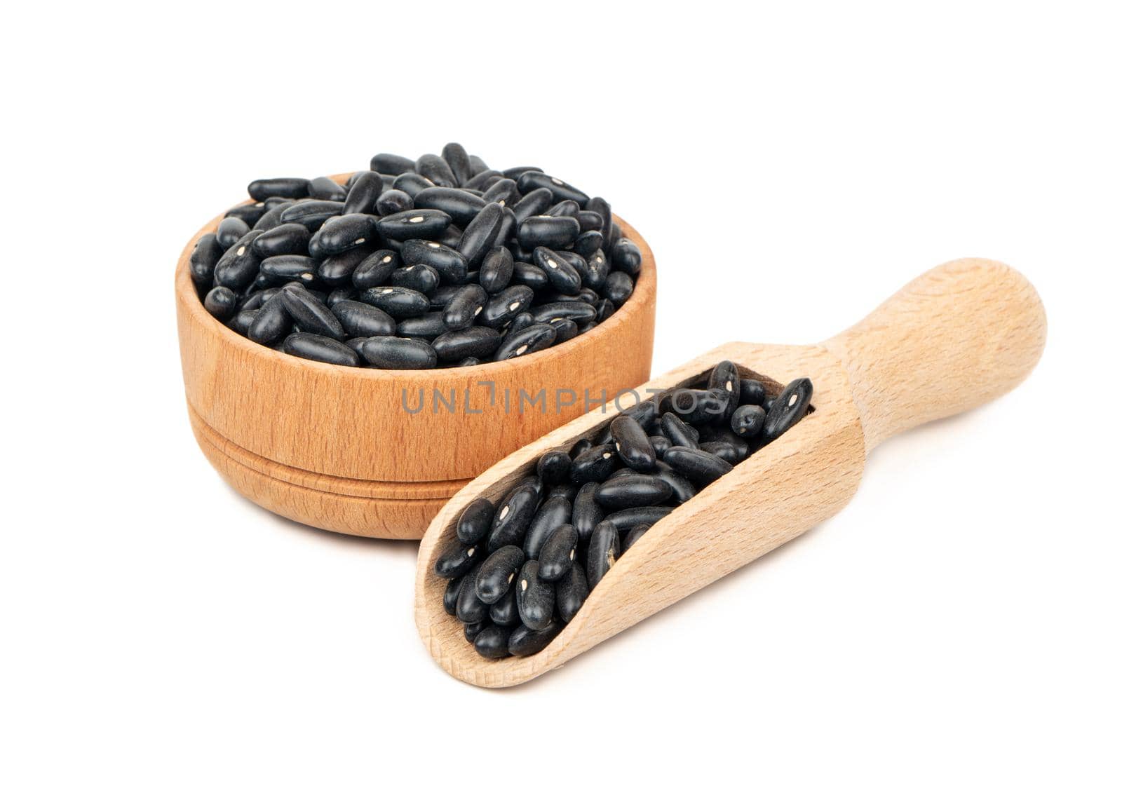 Black beans in bowl and wooden scoop on white background