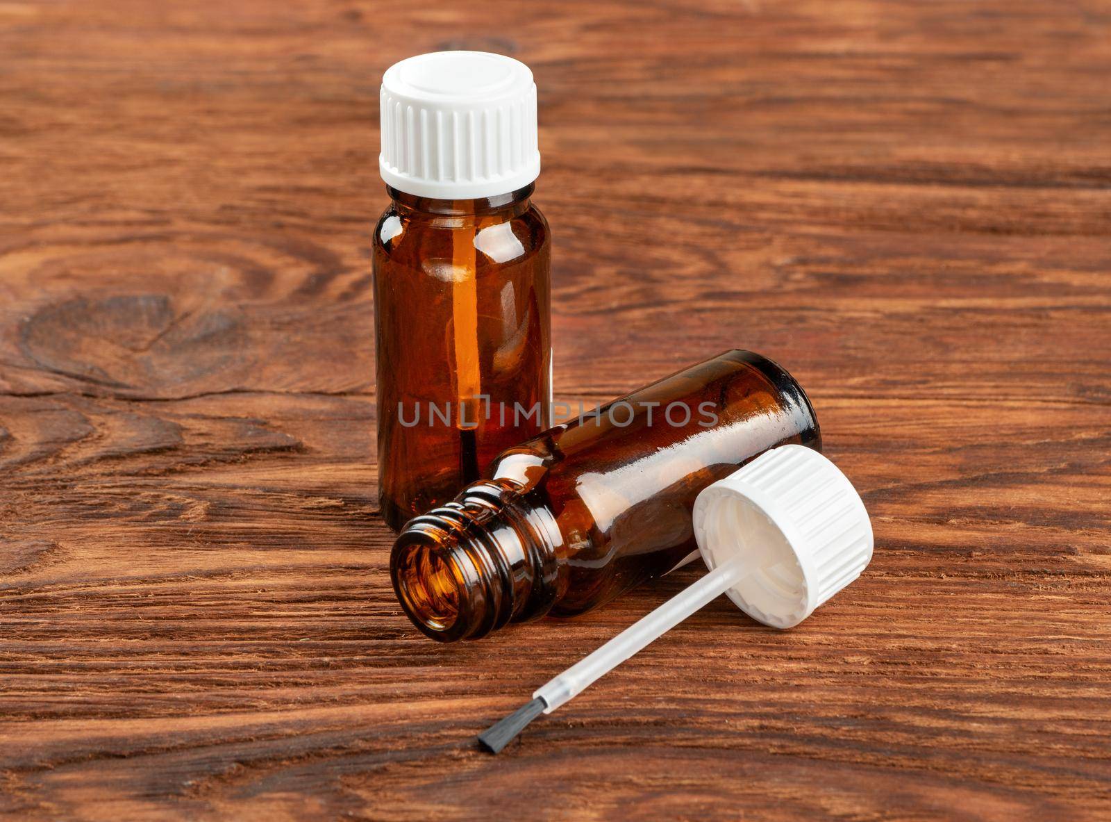 Nail polish bottle on brown wooden background