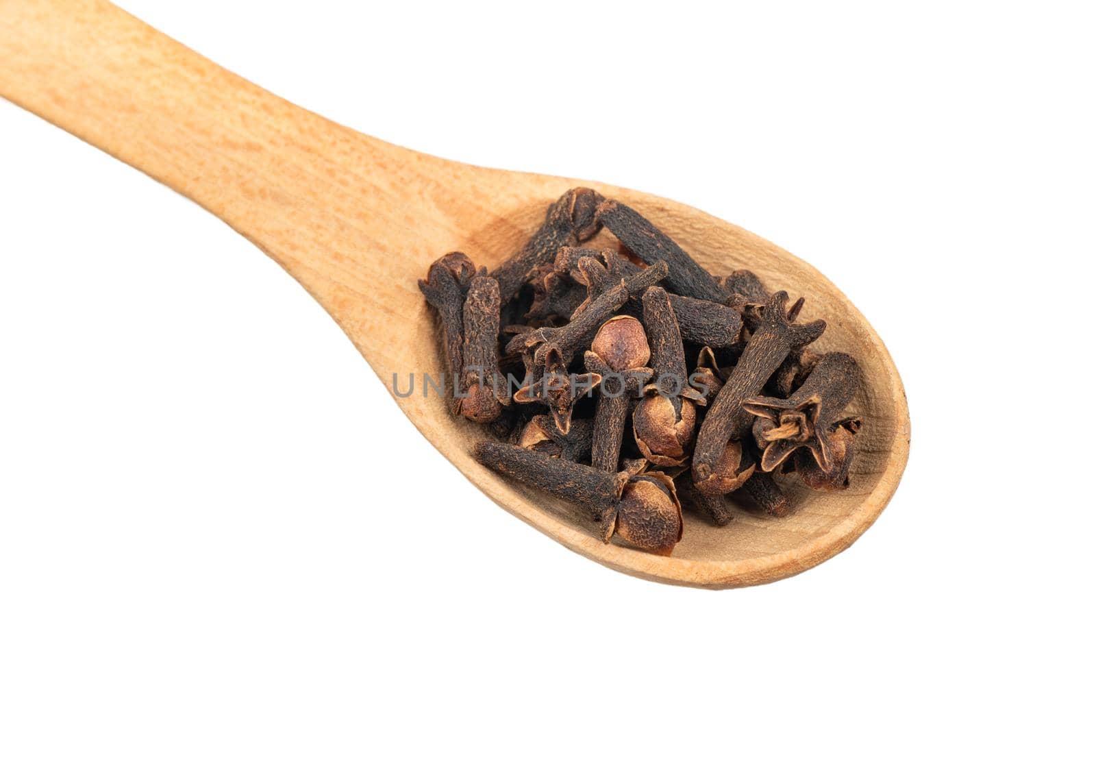 Wooden spoon with dry cloves isolated on white background closeup