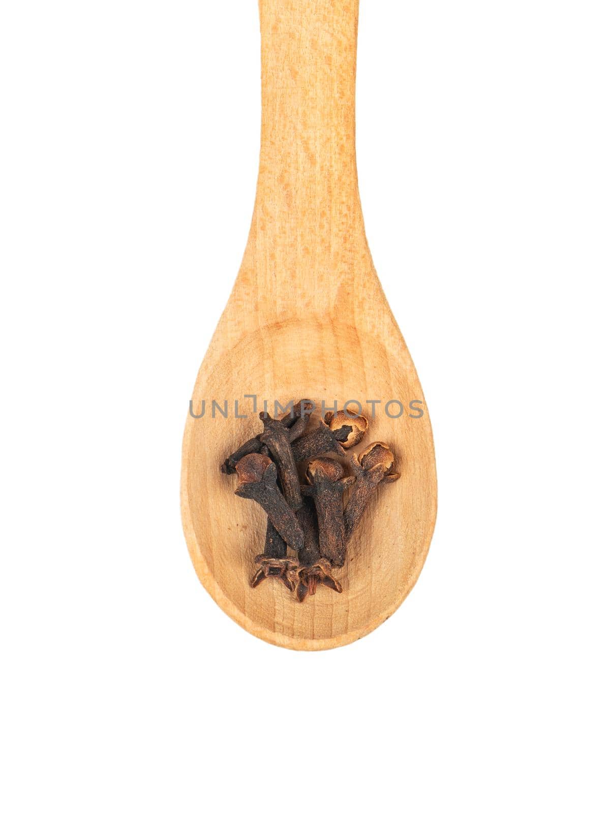 Wooden spoon with dry cloves isolated on white background closeup, top view