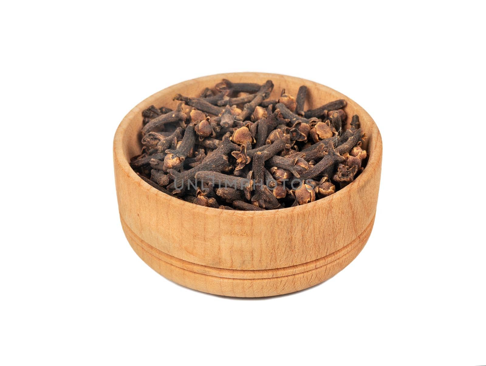 Dry cloves in wooden bowl isolated on white background