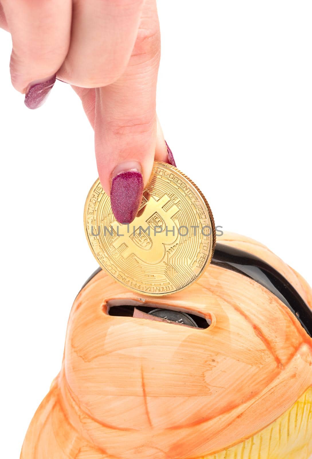 Female hand puts in piggy Bank bitcoin gold coin on white background