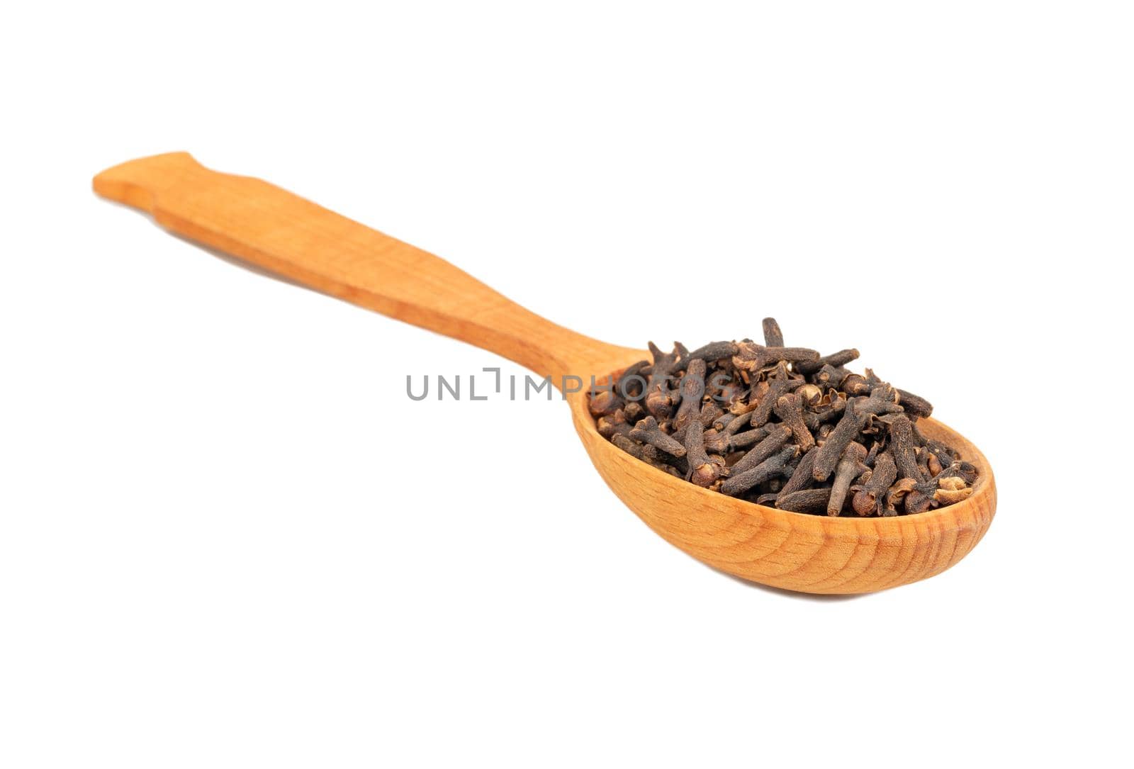 Wooden spoon with dry spice cloves on white background closeup