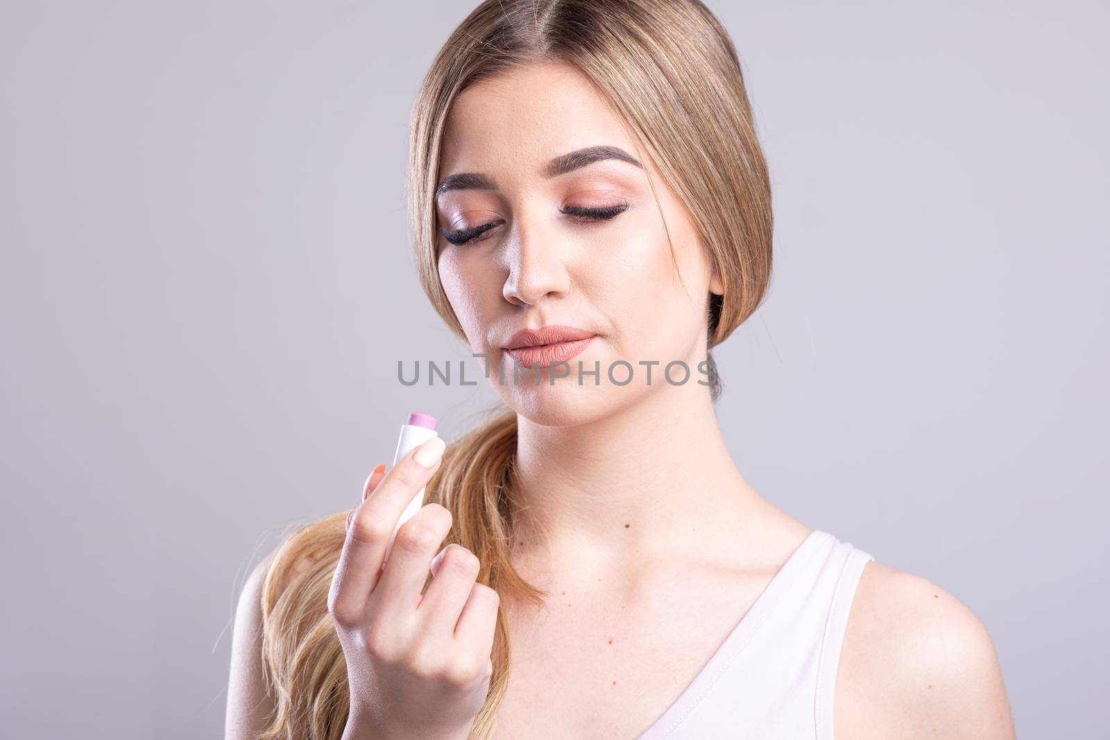 Beautiful Woman With Beauty Face Applying Lip Balsam, Lips Skin Care. Lipbalm On Sexy Lips by adamr