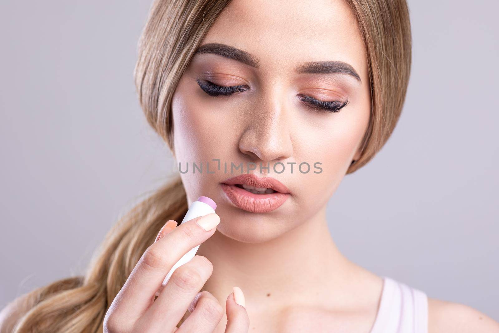 Beautiful Woman With Beauty Face Applying Lip Balsam, Lips Skin Care. Lipbalm On Sexy Lips. Portrait Of Female Model With Soft Skin And Natural Nude Makeup. High Resolution Stock Photo