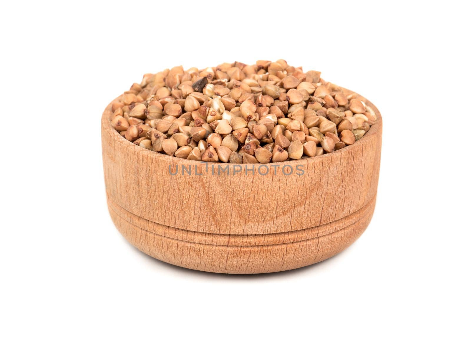 Dry grain buckwheat in a wooden bowl on a white background