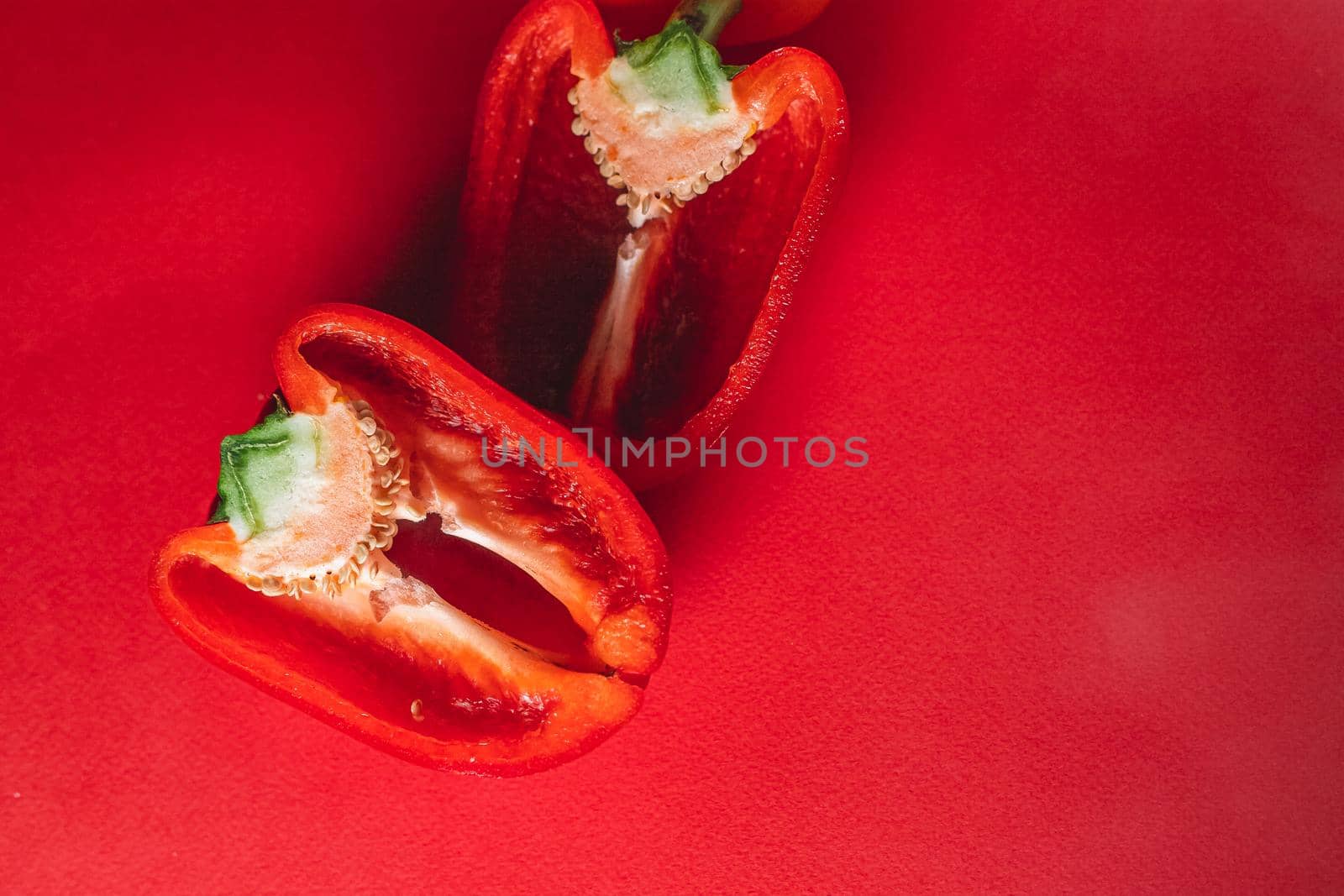 SWEET, fresh RED PEPPER ON A RED BACKGROUND, cut in half. photo for the menu, proper nutrition. fresh vegetables.