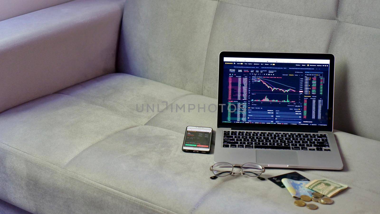 Laptop and phone to buy bitcoin on the Binance crypto exchange during the market crash. Trading, spot, staking. Workspace freelance flatlay