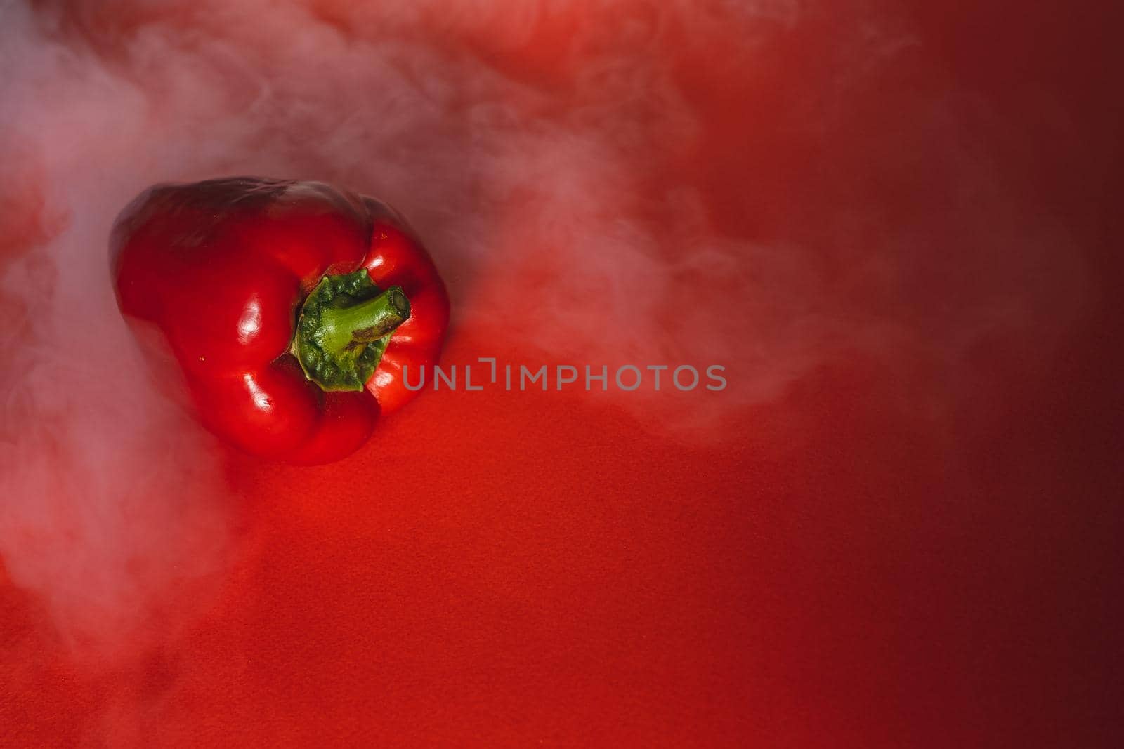SWEET, fresh RED PEPPER ON RED BACKGROUND With smoke around, pepper. photo for the menu, proper nutrition. fresh vegetables.