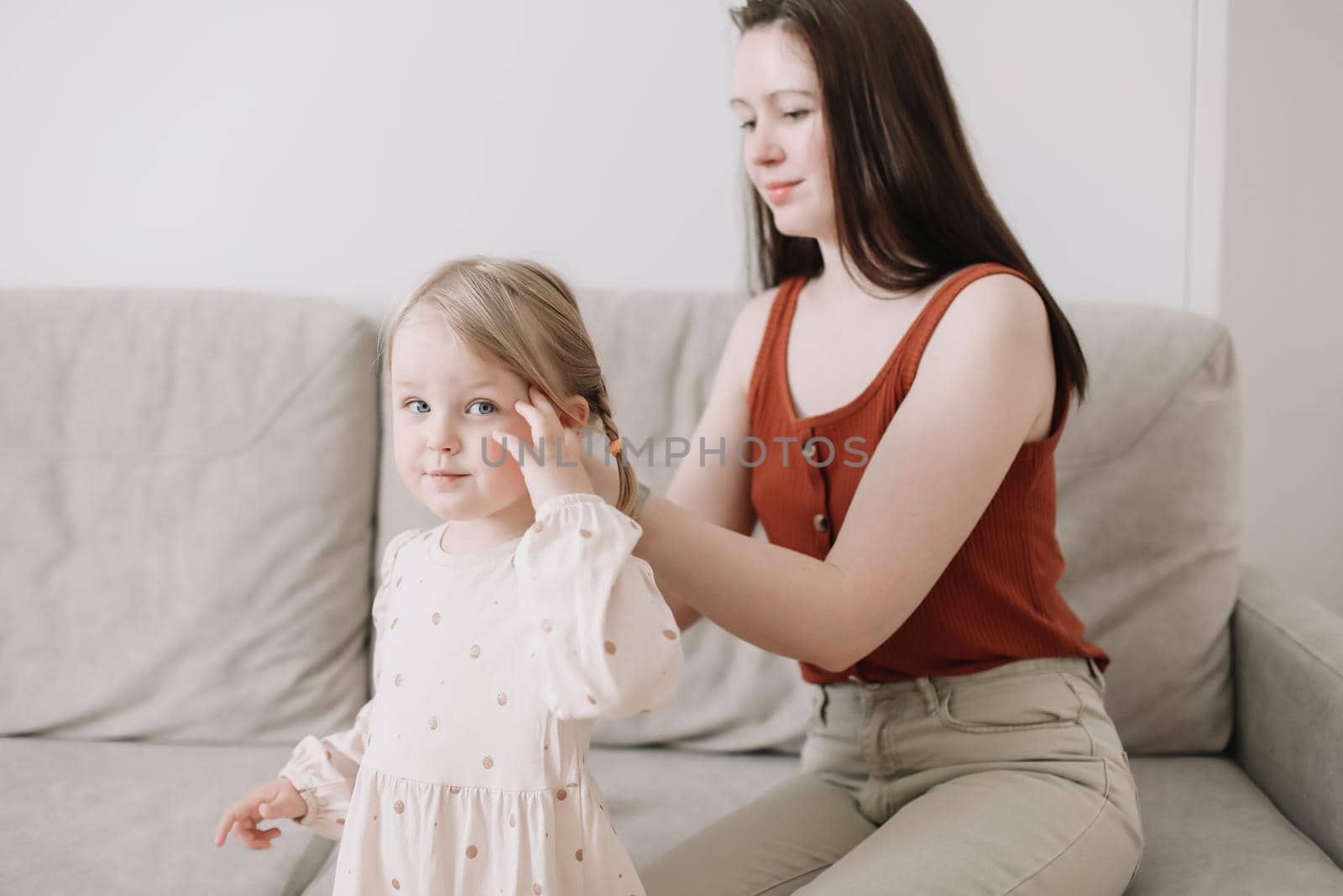 Cheerful toddler daughter and happy mother in a cozy light room at home. Mother's Day love family parenthood childhood concept