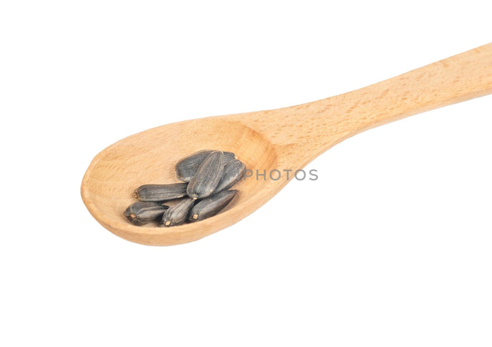 Sunflower seeds in a small wooden spoon on a white background closeup