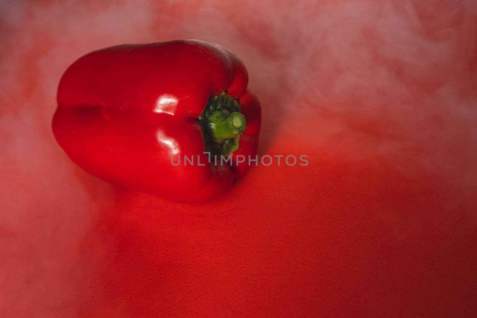 SWEET, fresh RED PEPPER ON RED BACKGROUND With smoke around, pepper. photo for the menu, proper nutrition. fresh vegetables.