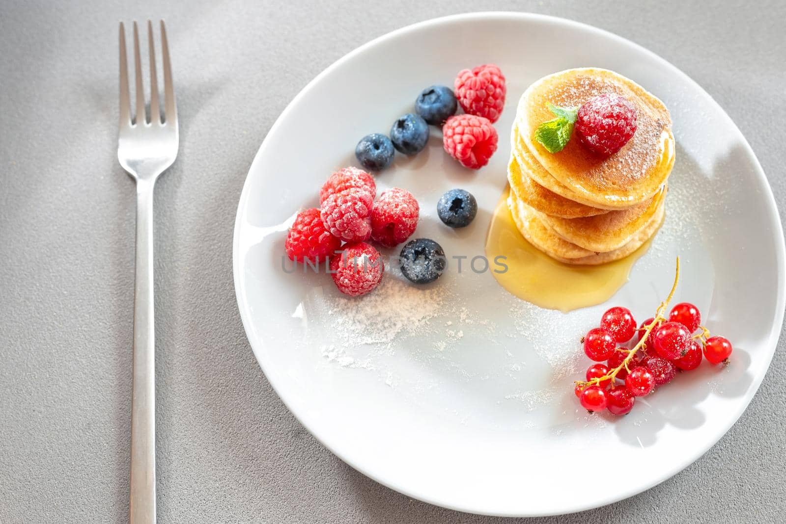 Food for breakfast healthy eating. Pancakes without butter with berries. Food for vegetarians and for dieting. American Pancakes Mini. Mini pancakes with blueberries and raspberries. American breakfast on a dark background. Healthy eating for the whole family. Homemade pancakes with berries. by gulyaevstudio