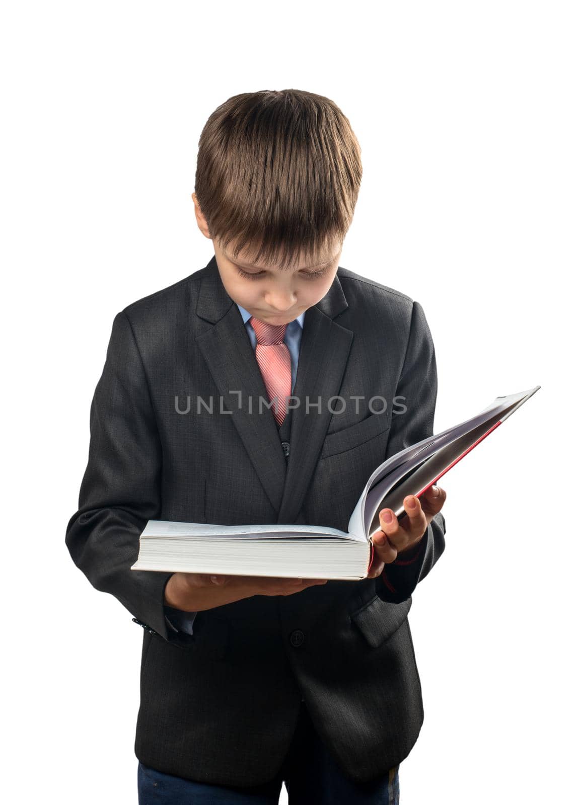 Schoolboy reading a big book in his hands on a white background