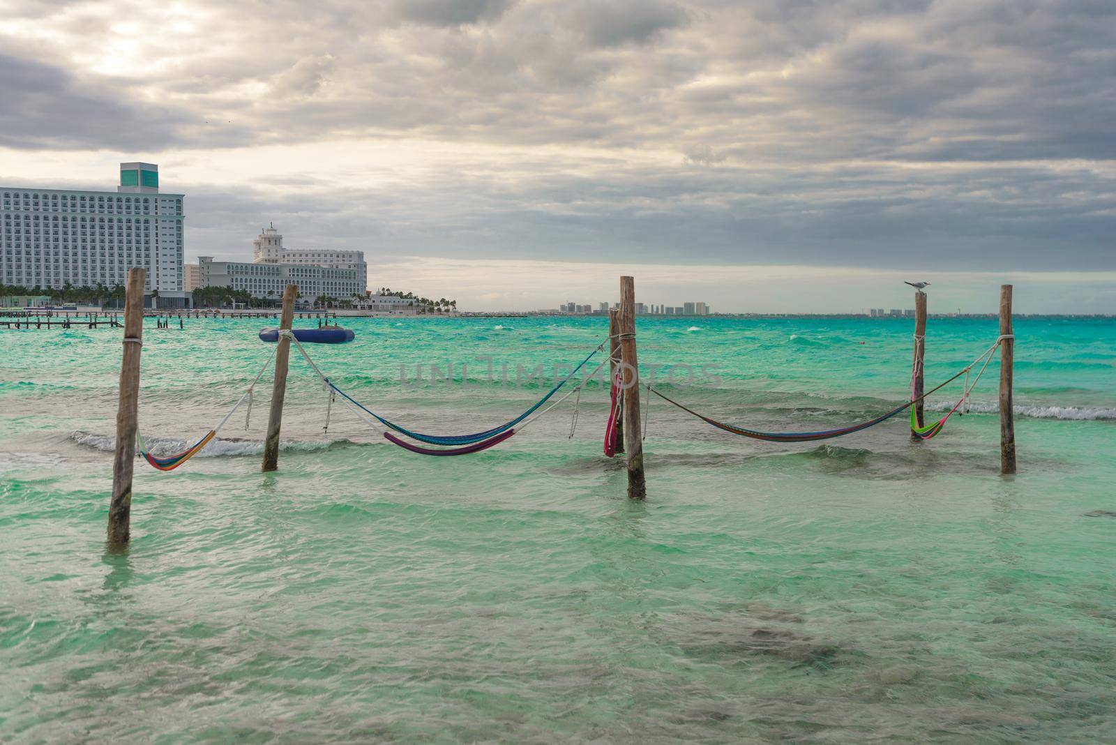 Hammocks hang on poles in the Caribbean.