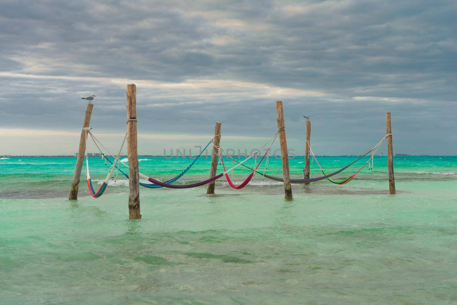 Hammocks hang on poles in the Caribbean.