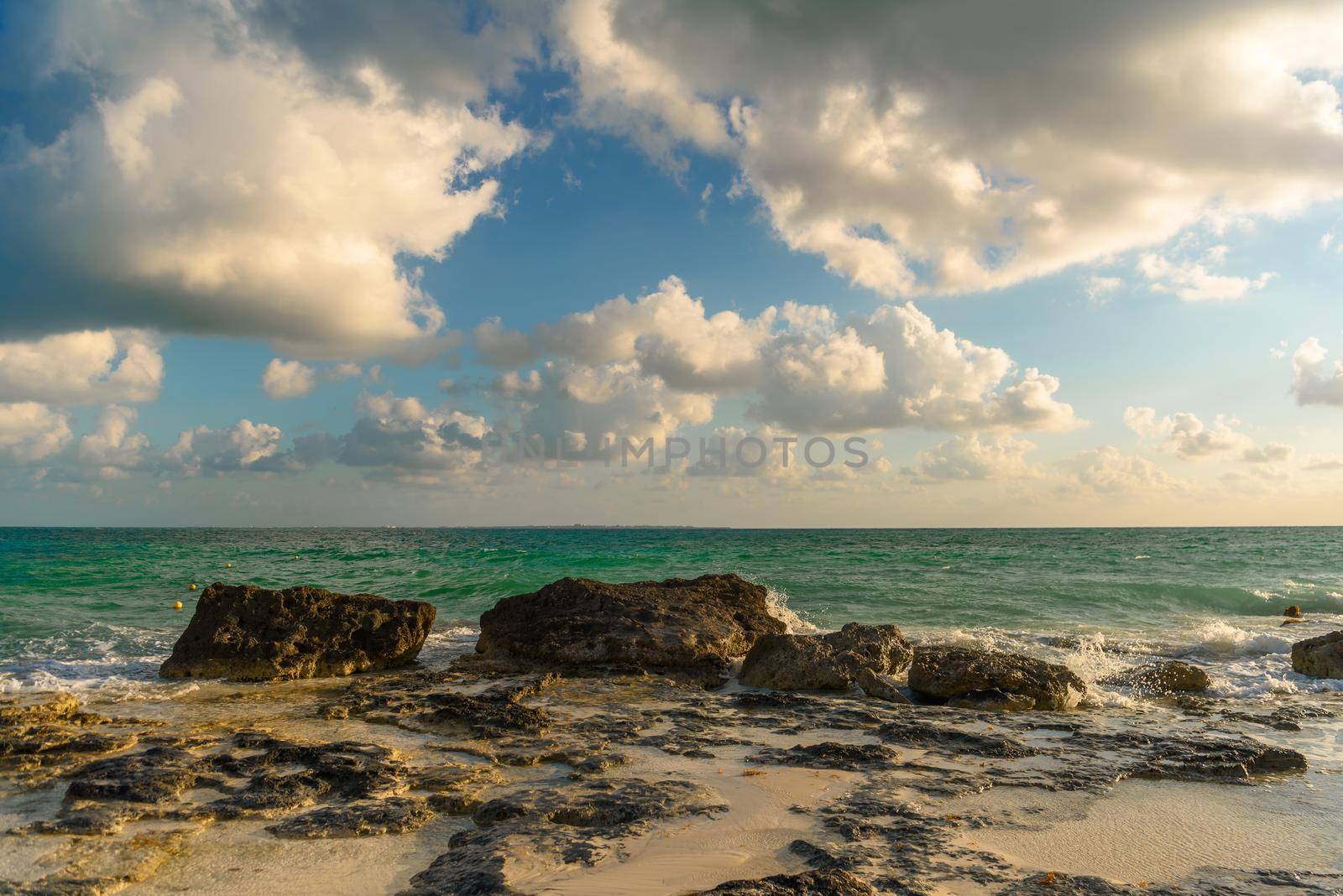 The coastline of the Caribbean Sea with white sand and rocks in Cancun.