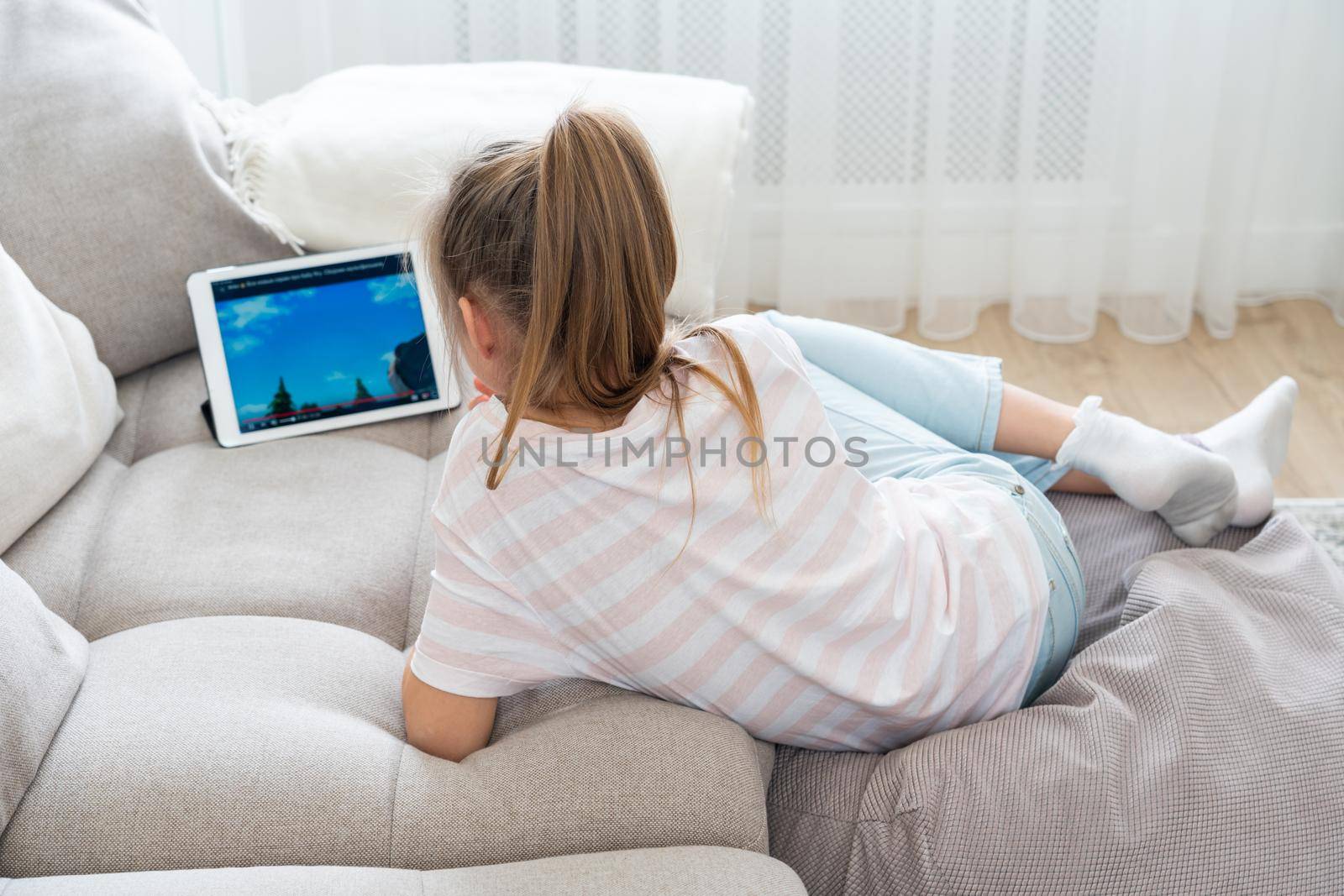 Girl Lying On Couch And Using Tablet by Mariakray