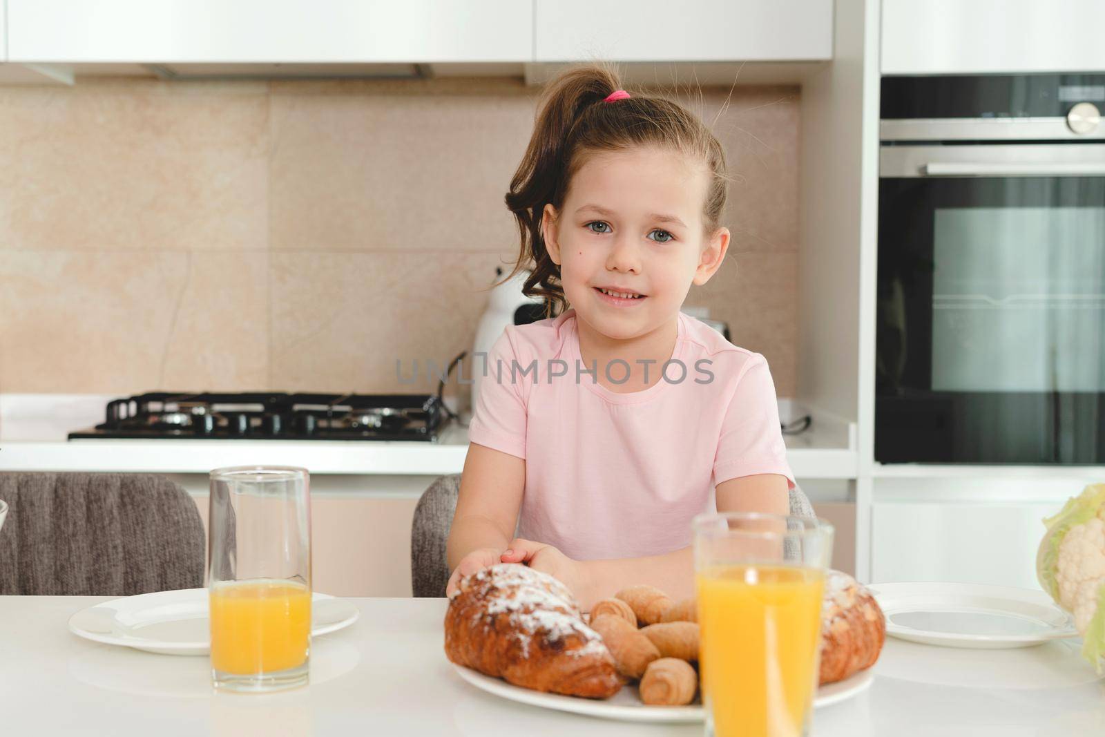 Pretty girl eating breakfast in the kitchen alone by Mariakray