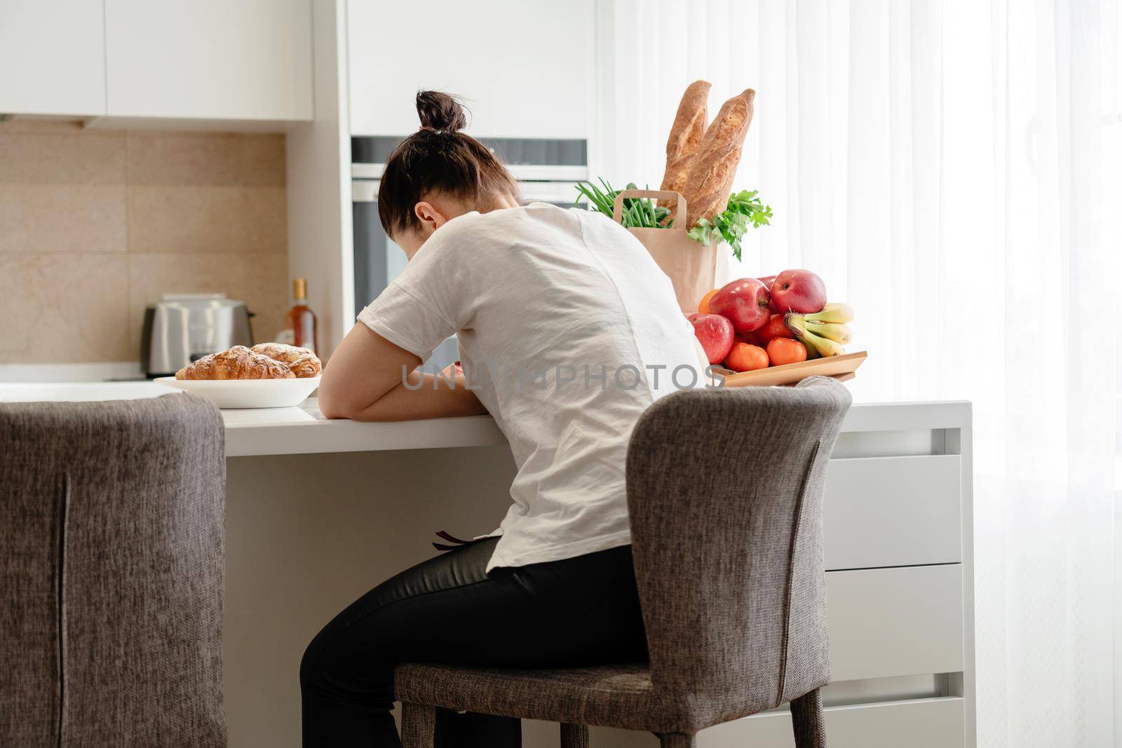 Young sad woman suffering in kitchen, Stressed housewife in kitchen by Mariakray