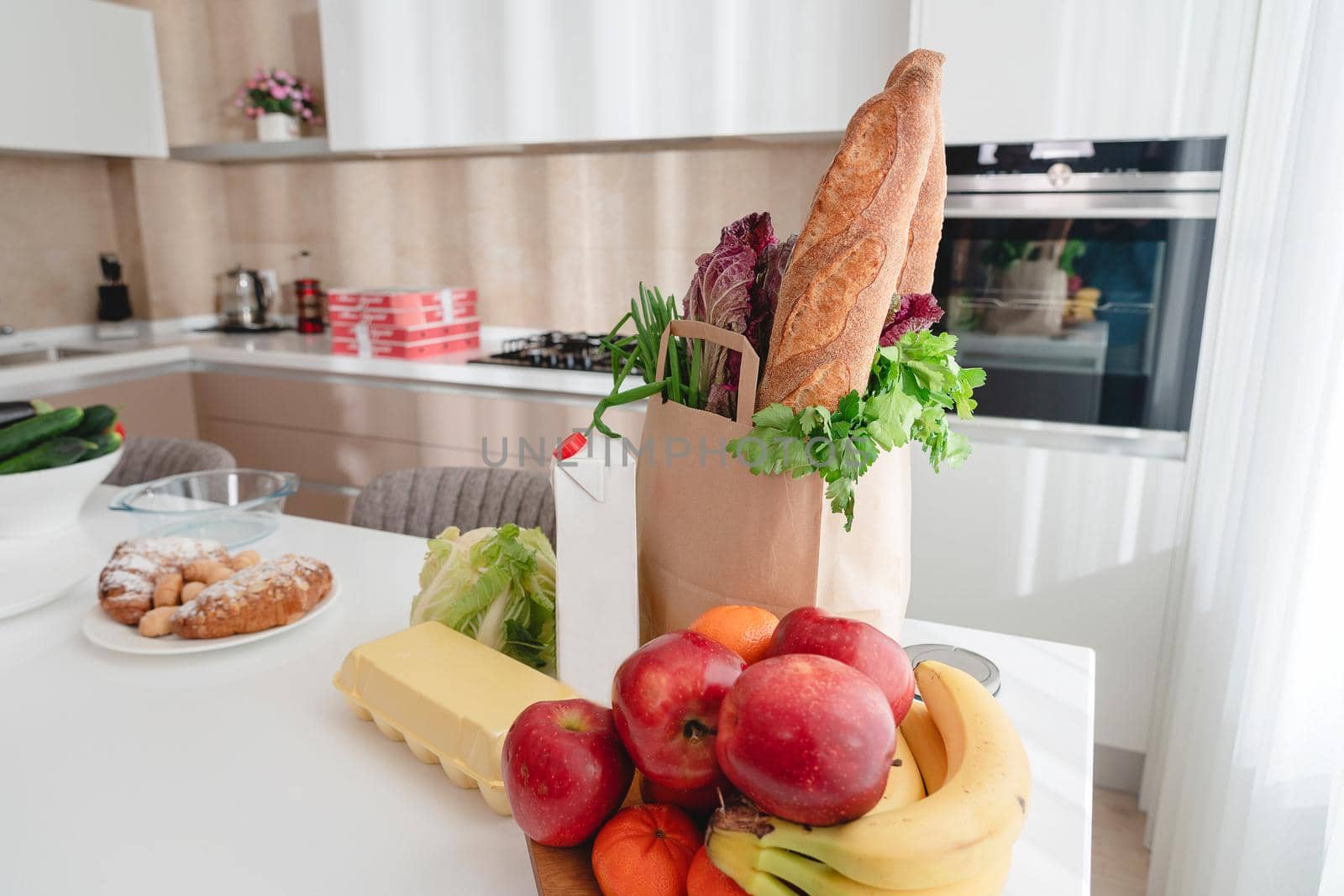 Paper bag with vegetables and bread, grocery with copy space on kitchen table by Mariakray