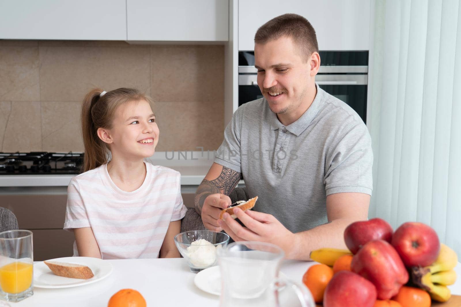 Father and daughter eating breakfast at kitchen