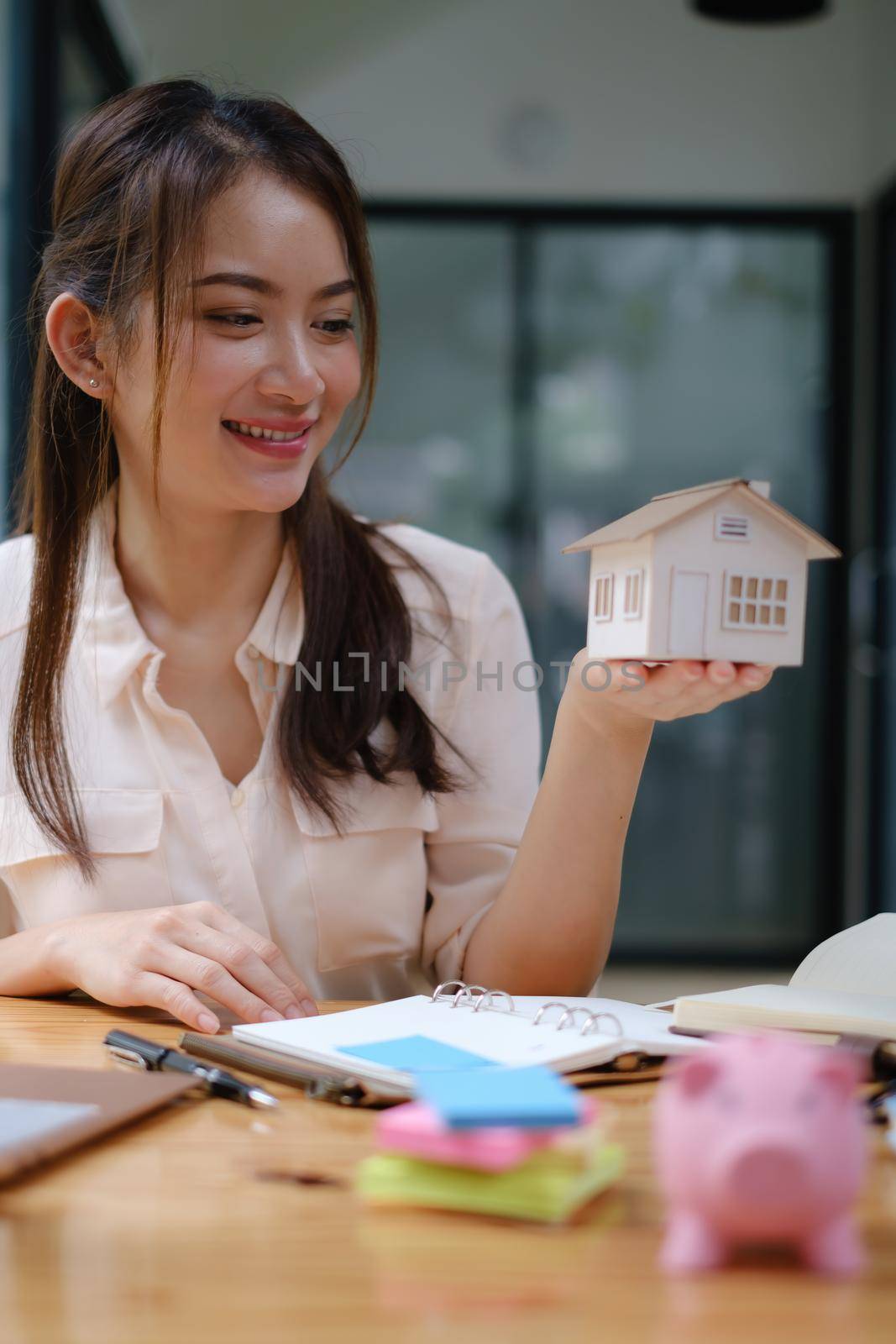 A real estate agent demonstrates the House model to clients interested in purchasing house insurance. The concept of home insurance and property