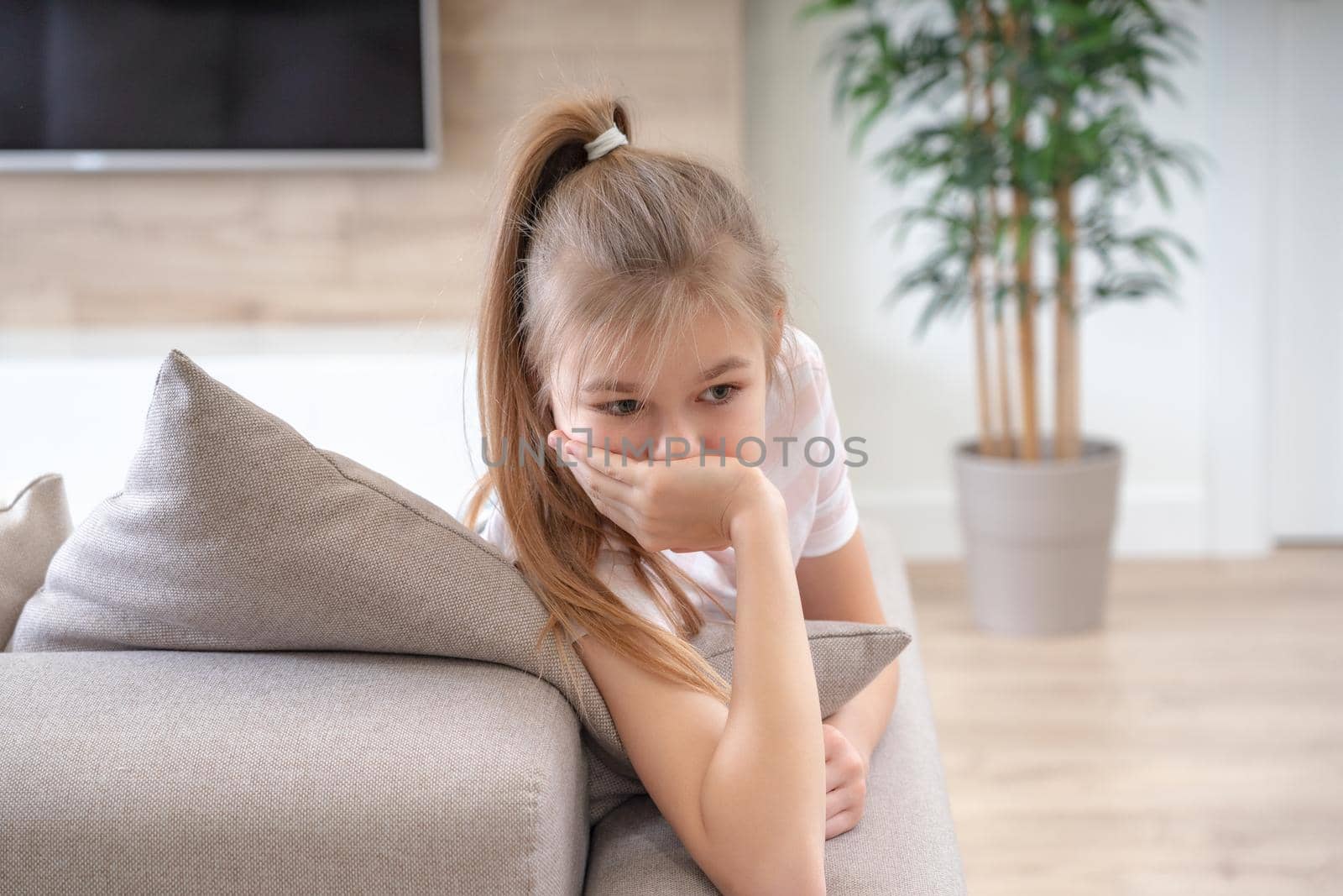 A little girl sitting on a couch. High quality photo