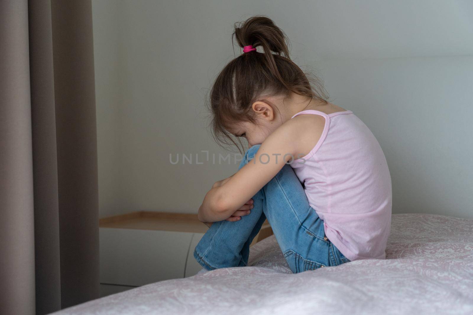 A little girl sitting on a bed