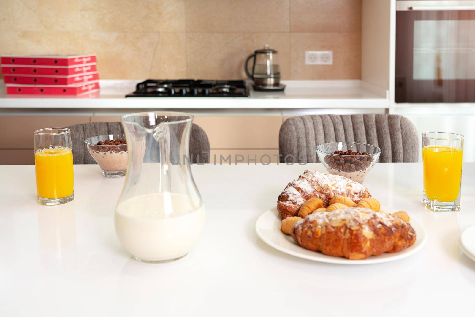 Breakfast is ready on the table in kitchen, Croissant, juice and milk