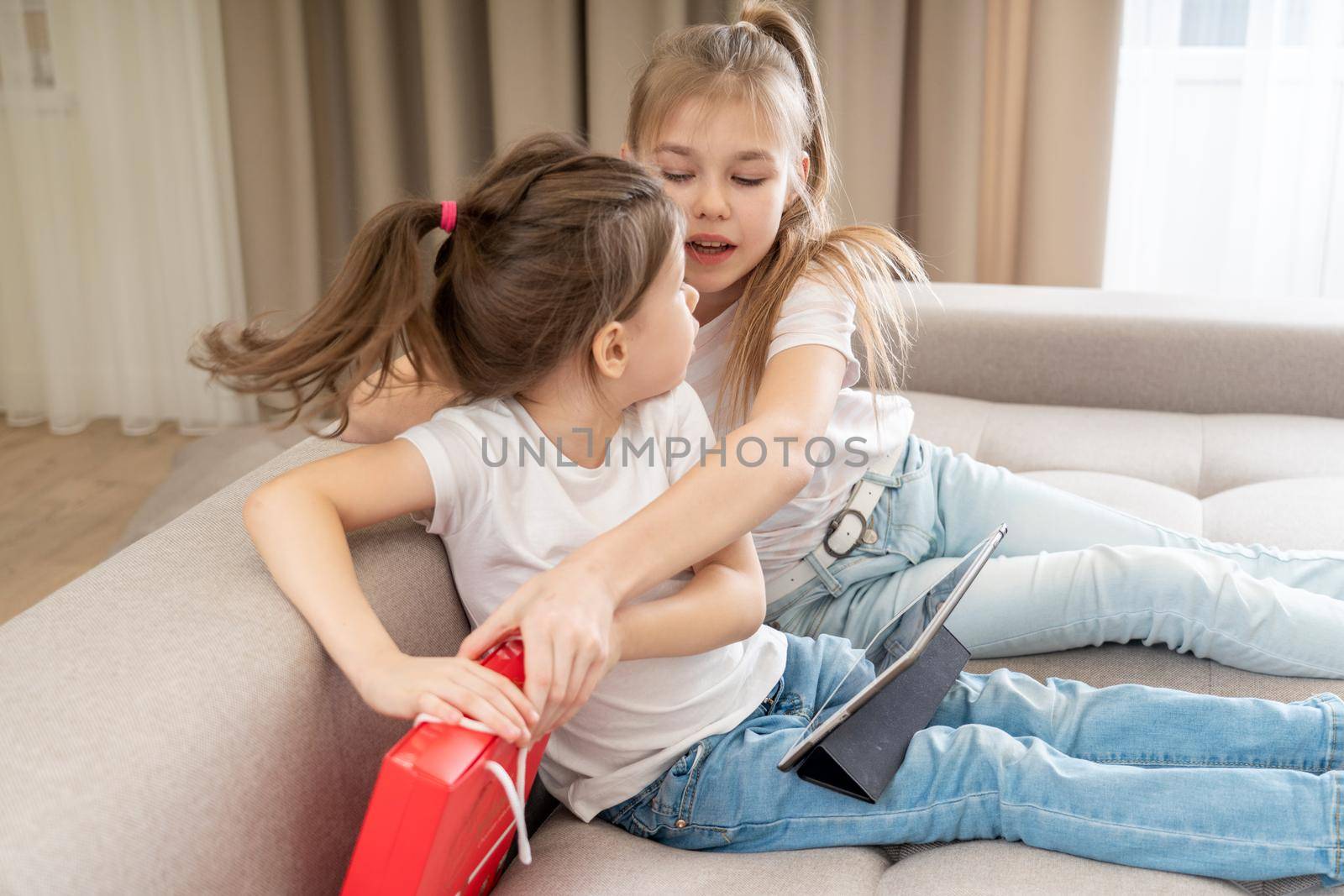 The present is mine. Little girls fight over present box. Giving present. Birthday present. Gift exchange. Holiday celebration.