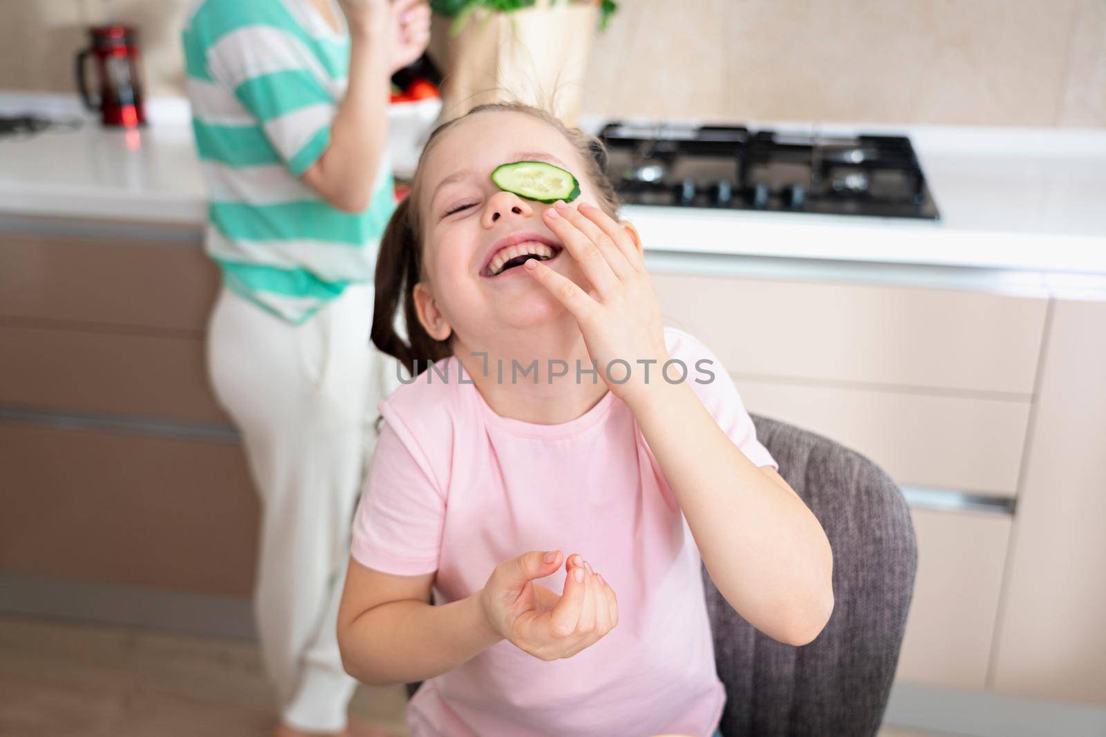 Happy young mother and daughter having fun in kitchen, happy single mother family concept by Mariakray