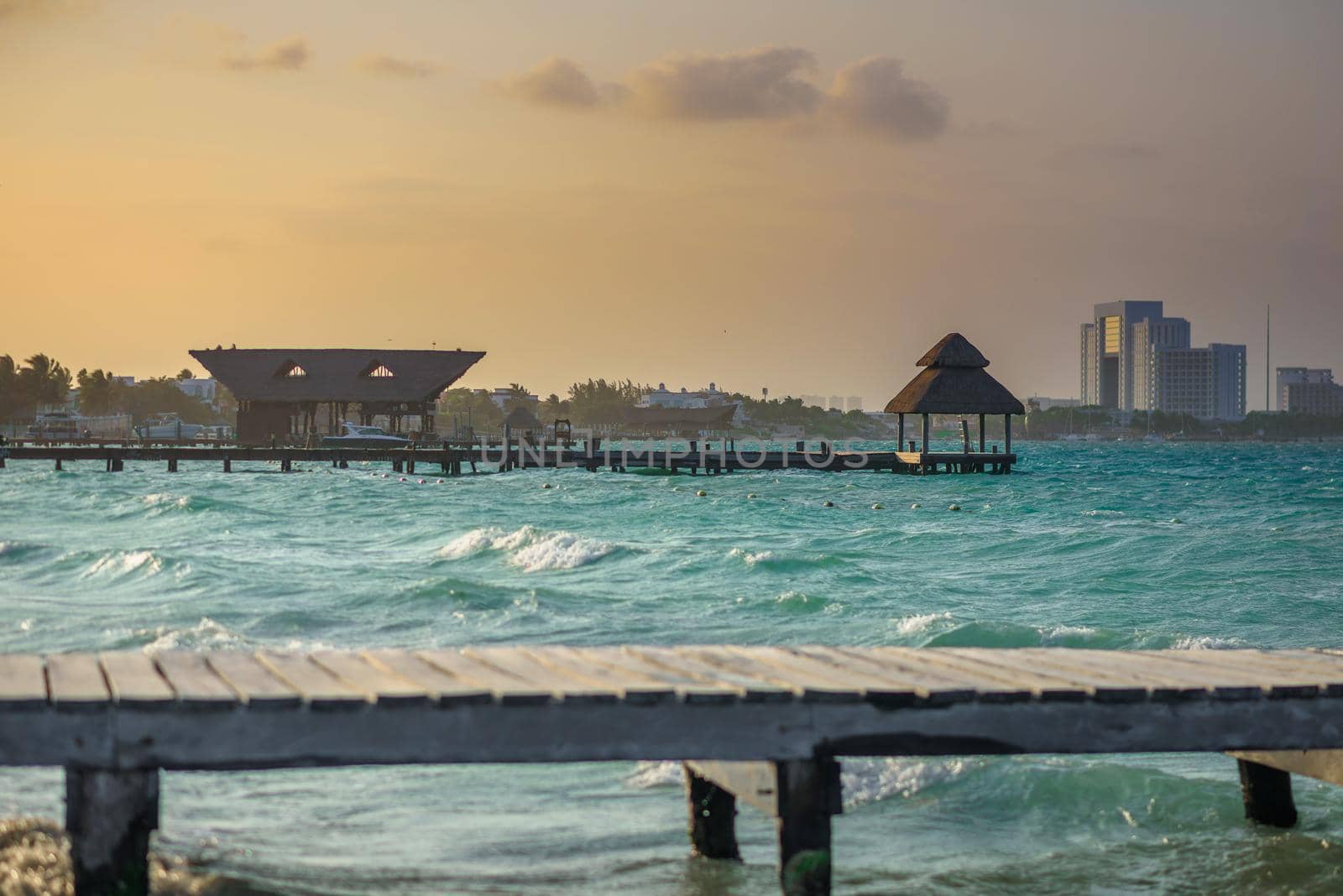 Pier on a beautiful sunset sun, with an azure sea. Wooden walkway