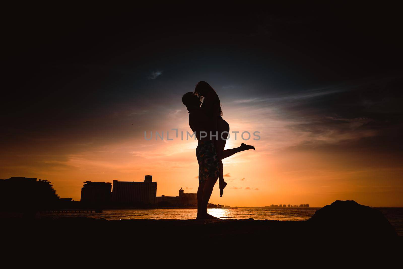 Silhouettes of men and women against the backdrop of the setting sun. Mexico.