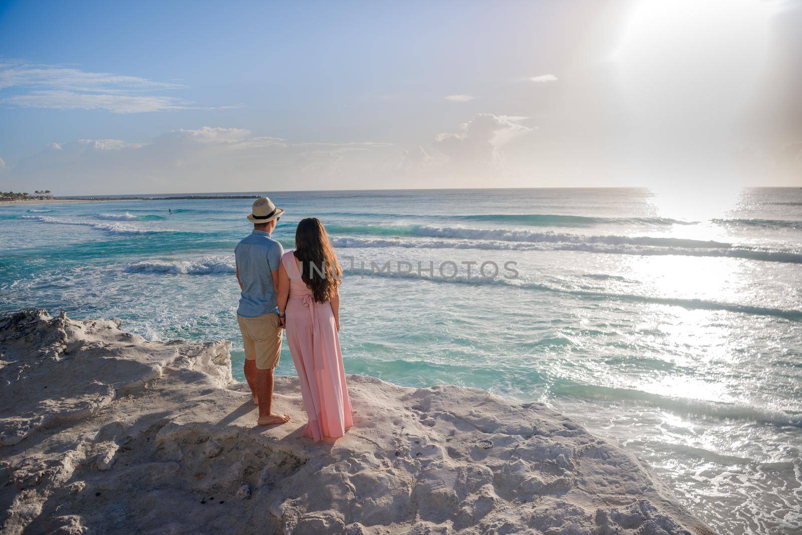 A man and a woman walk on the seashore.