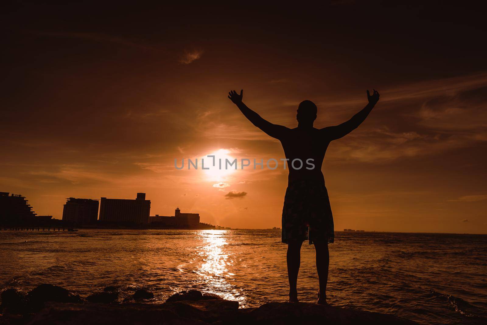 Silhouette of a man against the setting sun. Sunset.