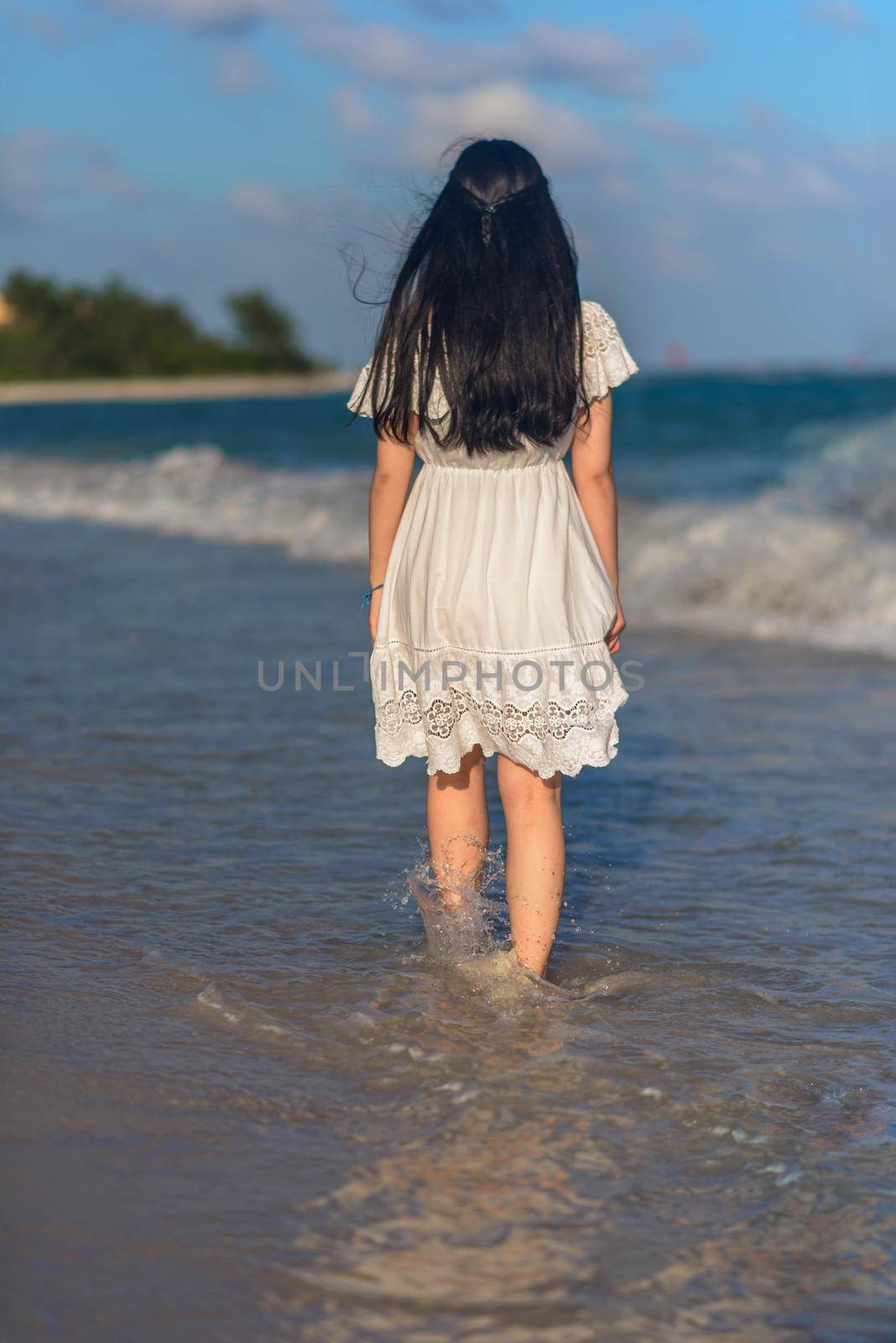 A woman on the beach looks at the horizon and walks along the beach. Mexico.