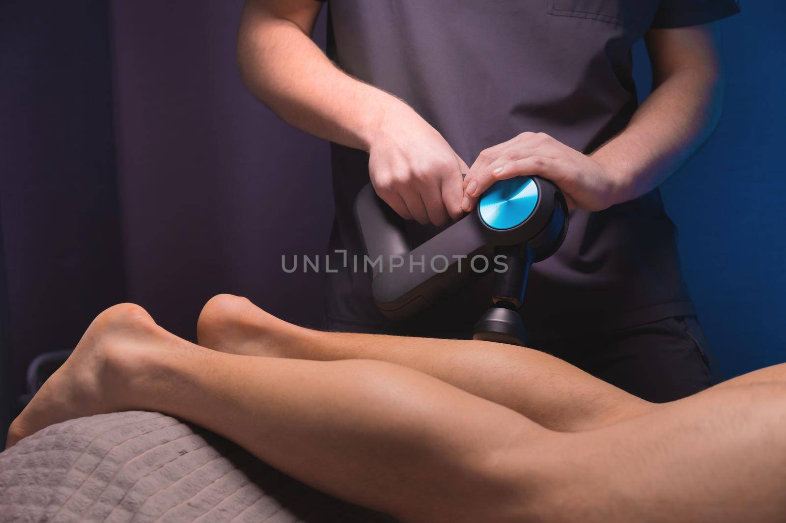 Rehabilitation. Massage therapist performs prophylactic percussive massage by yanik88
