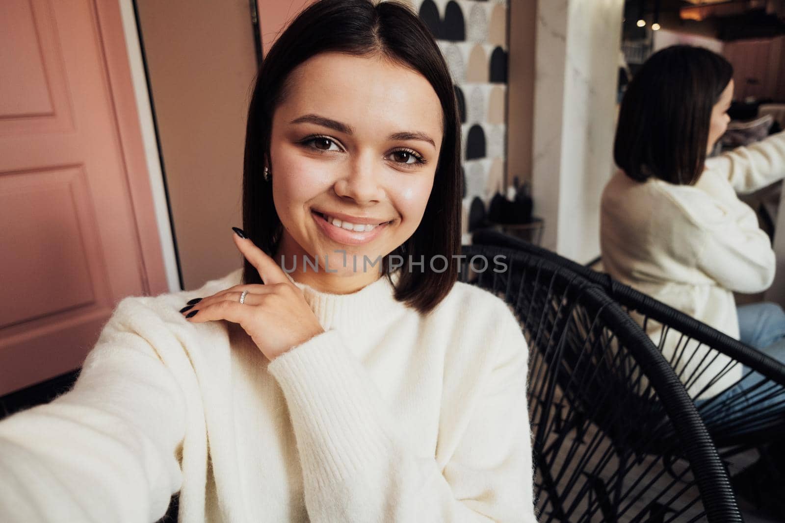 Young Woman Making Selfie While Sitting on Couch in the Hallway of Beauty Salon