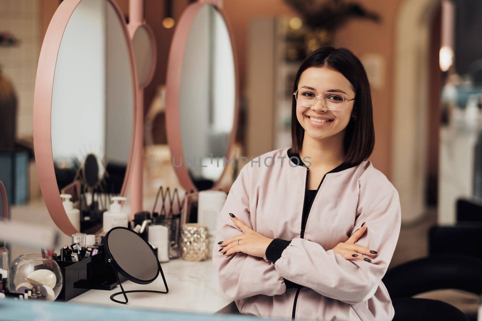Portrait of Caucasian Woman in Glasses with Folded Arms at Workplace, Young Cheerful Female Make Up Artist Standing in Beauty Salon