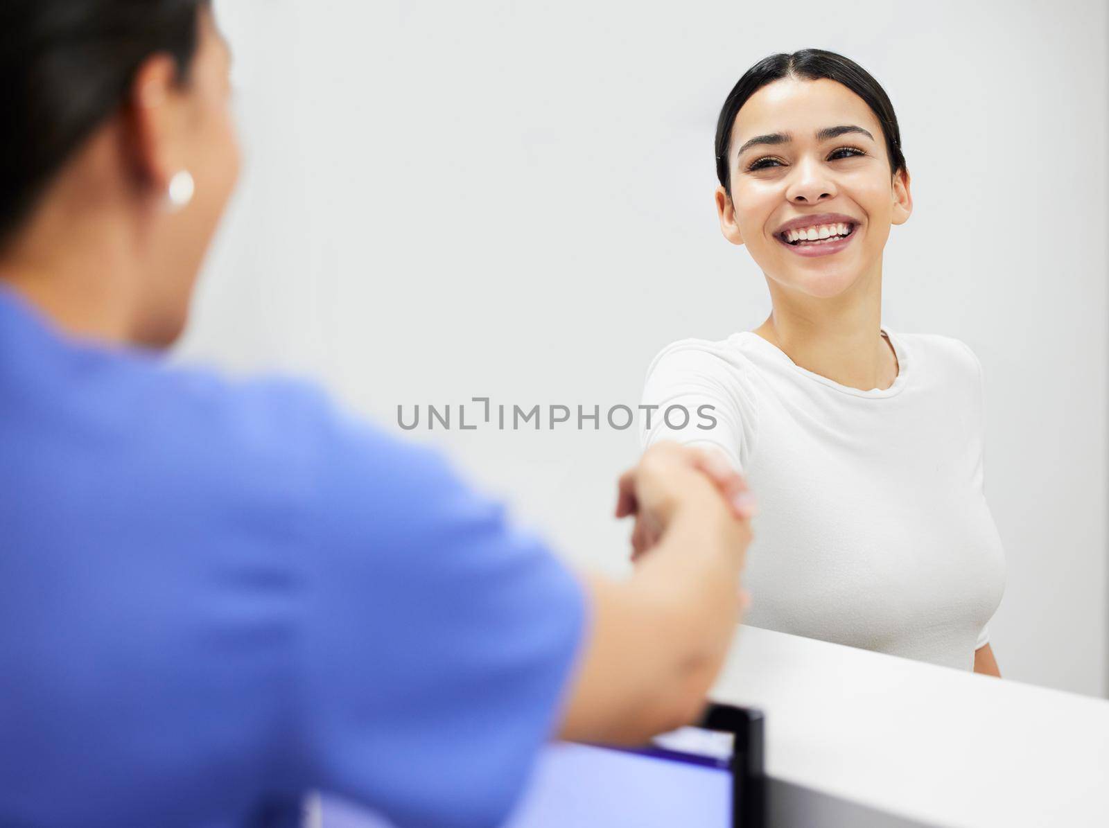 I always notice a persons smile. a nurse and patient shaking hands in a clinic. by YuriArcurs