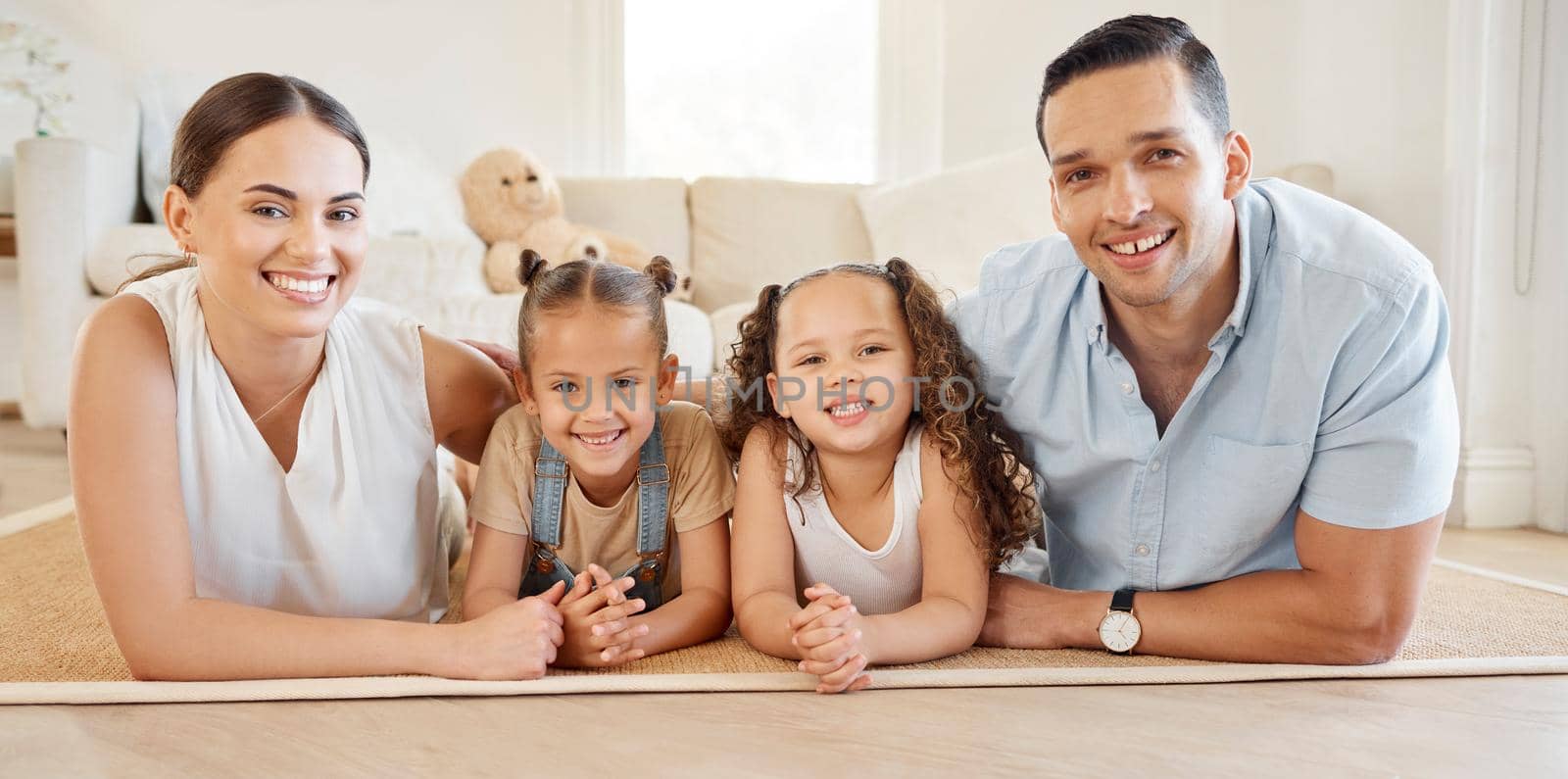 Togetherness is a very important ingredient to family life. a young couple bonding with their two young daughters at home. by YuriArcurs