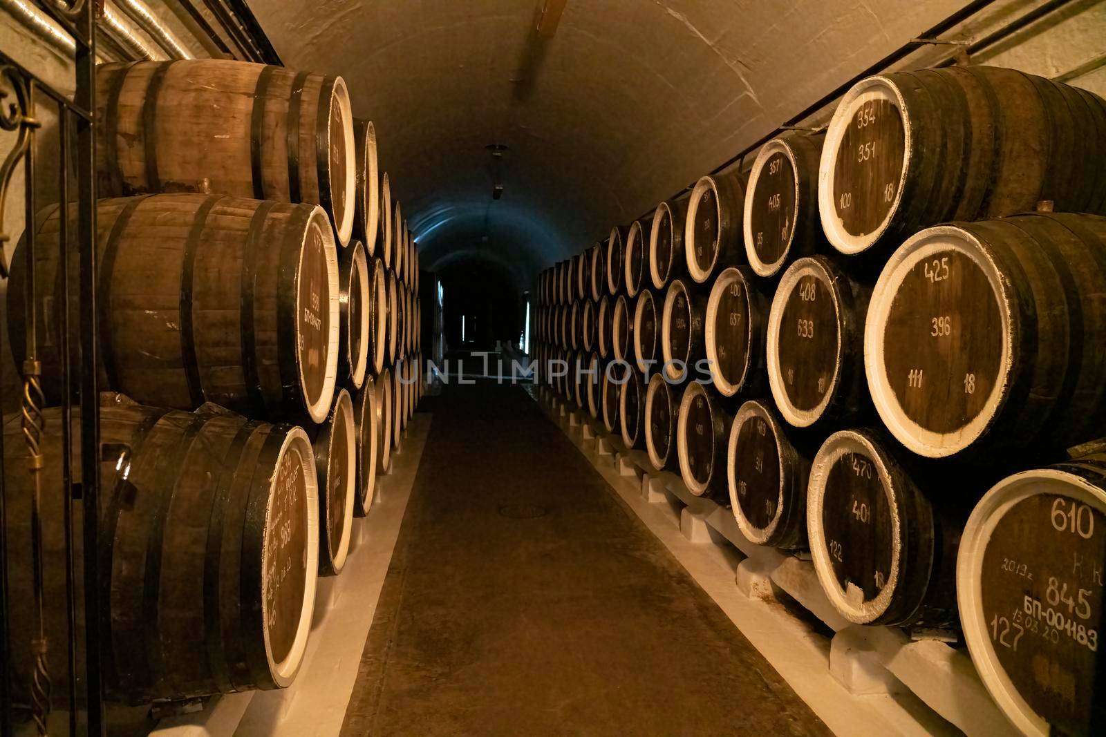 barrels of wine in wine cellars close-up by roman112007