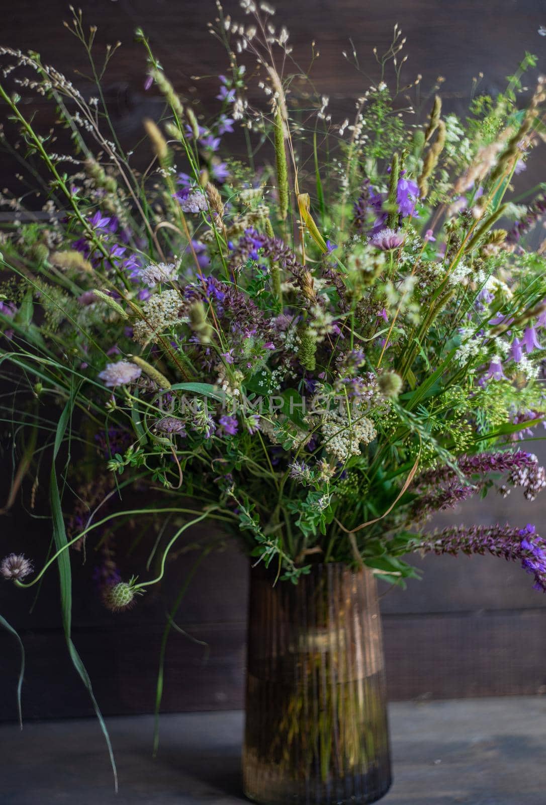 Beautiful wild flowers in bouquet on wooden table