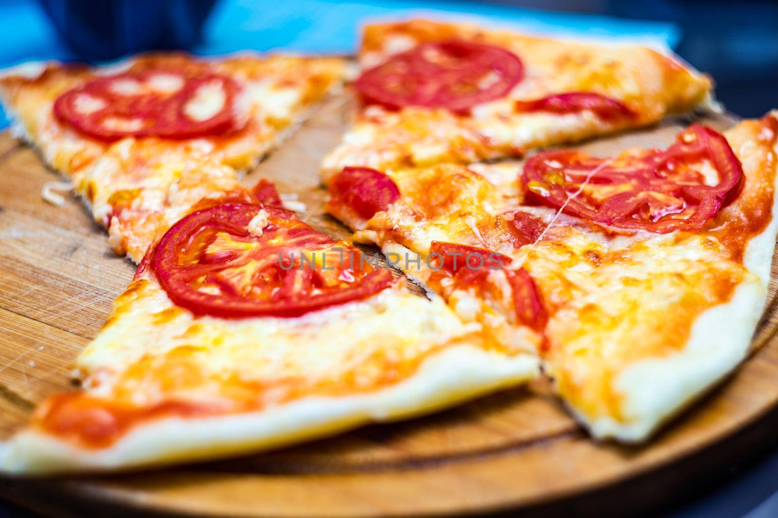 italian pizza with tomato and cheese in pieces