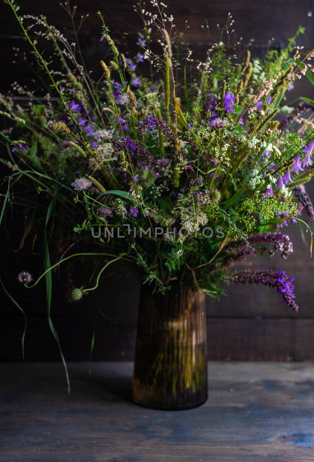 Beautiful wild flowers in bouquet on wooden table