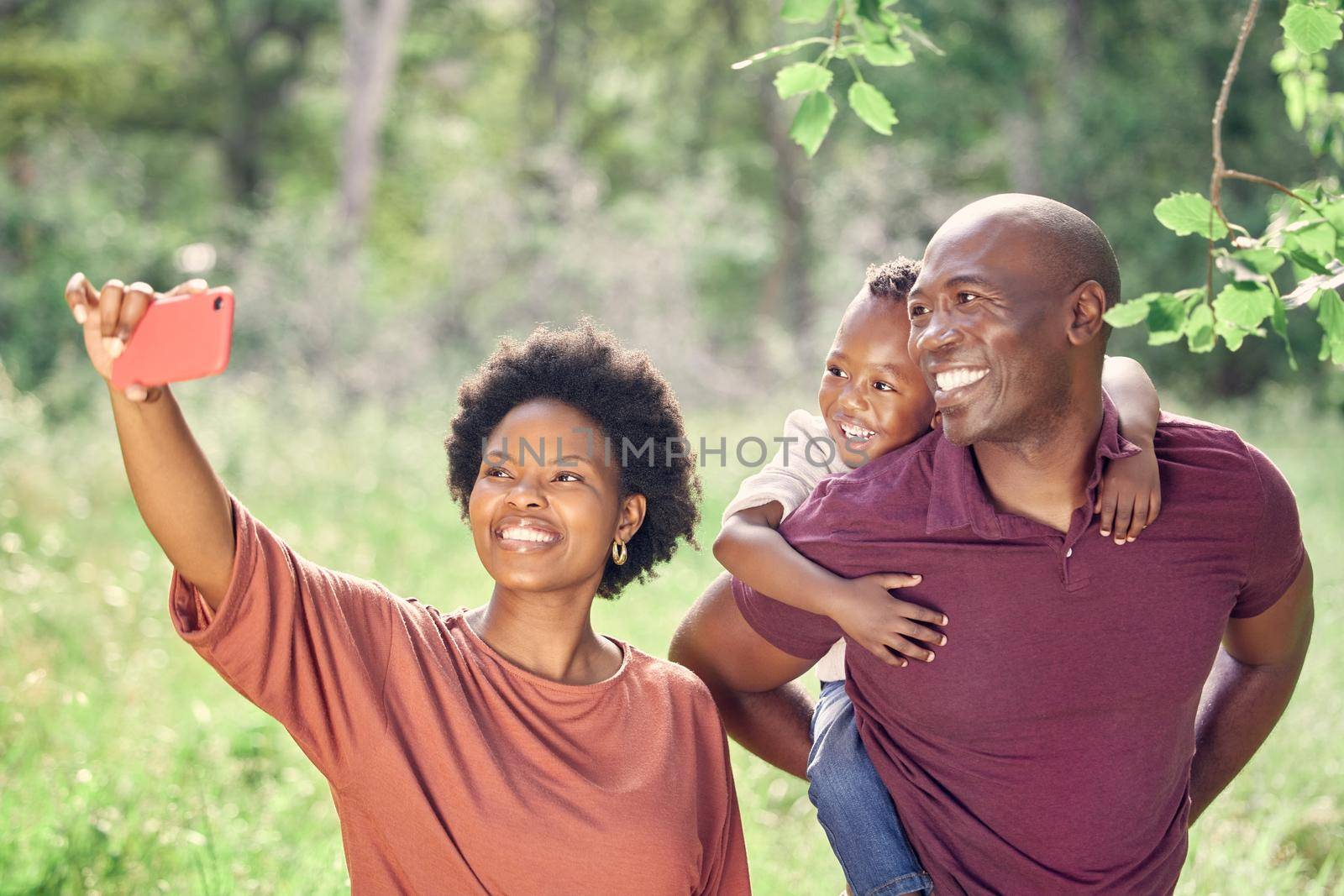 This is a selfie of my whole world. a woman taking a selfie while spending the day outdoors with her family. by YuriArcurs