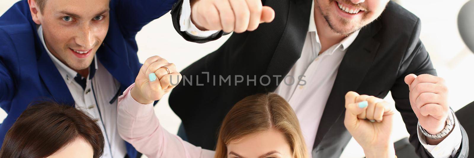 Top view of group of people show support gesture collectively in office. Well dressed workers posing with smile, cheerful mood. Business, teamwork concept